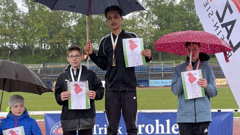 Sydney von Zons (M.) bei der Siegerehrung - bei Regen. (Copyright: TSV Bayer Dormagen)